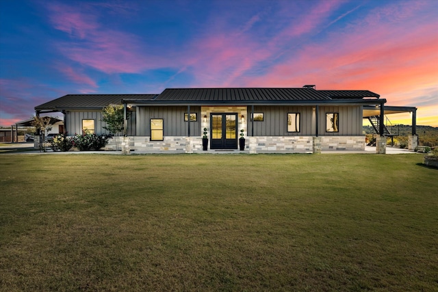 view of front of home with french doors and a yard