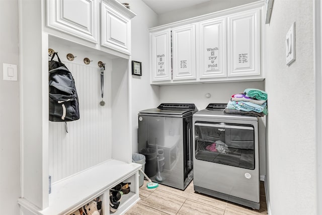 washroom with cabinets and washer and clothes dryer