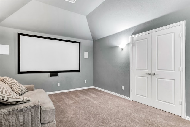 carpeted cinema room featuring vaulted ceiling