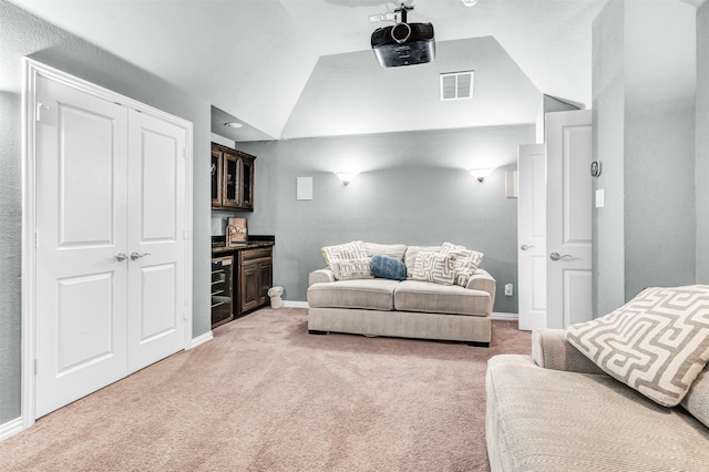 living room with light colored carpet, vaulted ceiling, and indoor wet bar