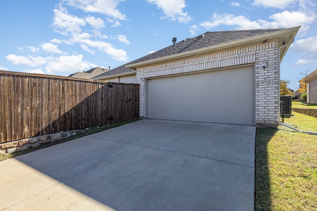 garage with a lawn and cooling unit