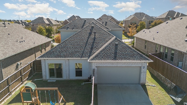 rear view of property featuring a playground, a garage, and a lawn