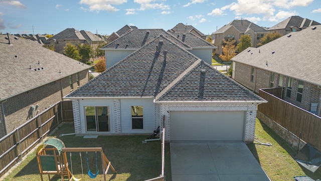 view of front of house featuring a playground, a front lawn, and a garage