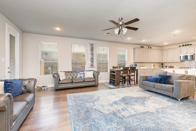 living room with ceiling fan and light wood-type flooring