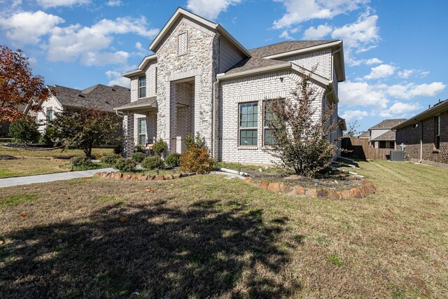 view of front of house featuring a front yard and central AC