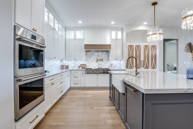 kitchen with white cabinets, pendant lighting, sink, and appliances with stainless steel finishes