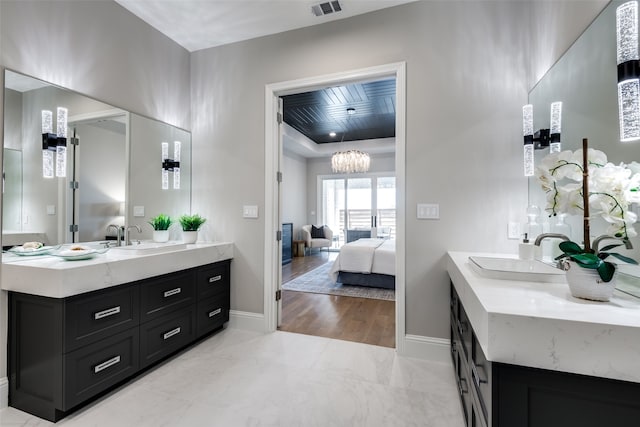 bathroom with vanity, wood-type flooring, and a notable chandelier