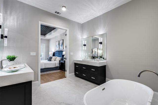 bathroom with a tub, vanity, and wood-type flooring