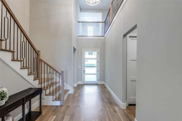 foyer entrance featuring a high ceiling and light wood-type flooring