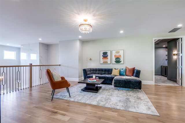 living room with light wood-type flooring and a chandelier