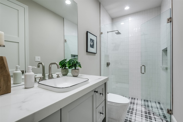 bathroom with vanity, toilet, and a shower with door