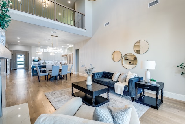 living room with a towering ceiling and light hardwood / wood-style floors