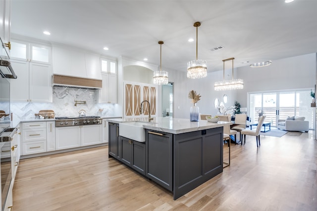 kitchen with white cabinets, decorative light fixtures, stainless steel gas cooktop, and sink