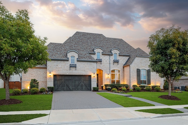 french country style house with a garage and a yard