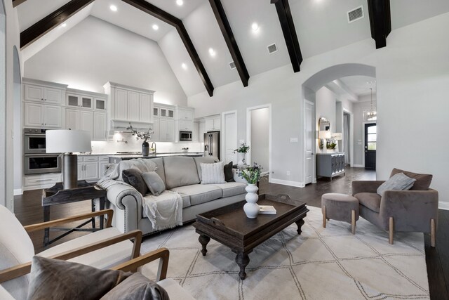 living room with beam ceiling and high vaulted ceiling