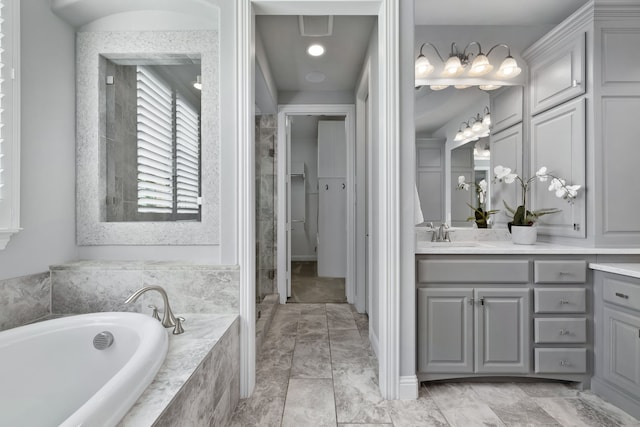 bathroom with vanity and tiled bath