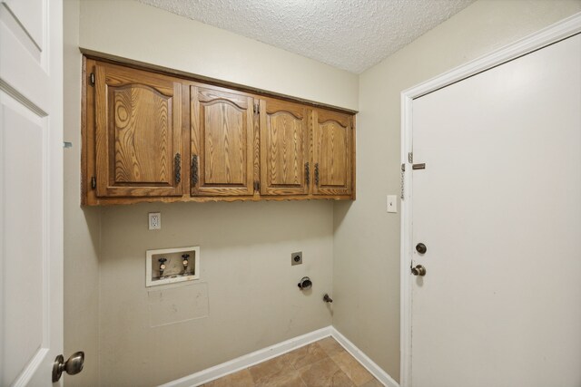 washroom featuring washer hookup, cabinets, hookup for an electric dryer, a textured ceiling, and light tile patterned flooring