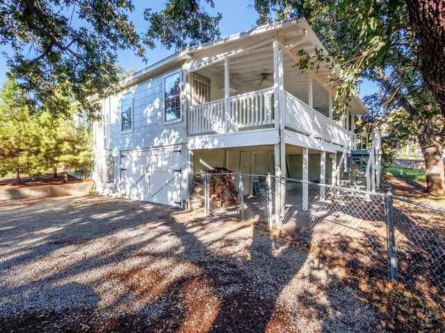 back of house with ceiling fan and a porch