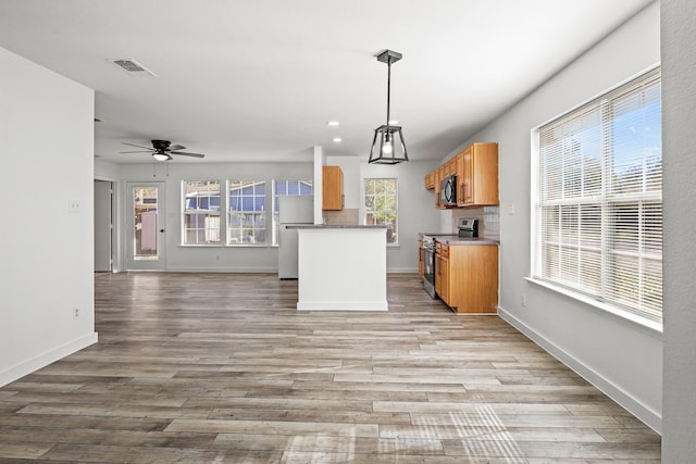 kitchen featuring light hardwood / wood-style floors, stainless steel electric range oven, hanging light fixtures, and ceiling fan