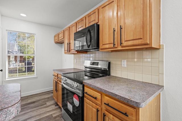 kitchen featuring electric stove, decorative backsplash, and dark hardwood / wood-style flooring