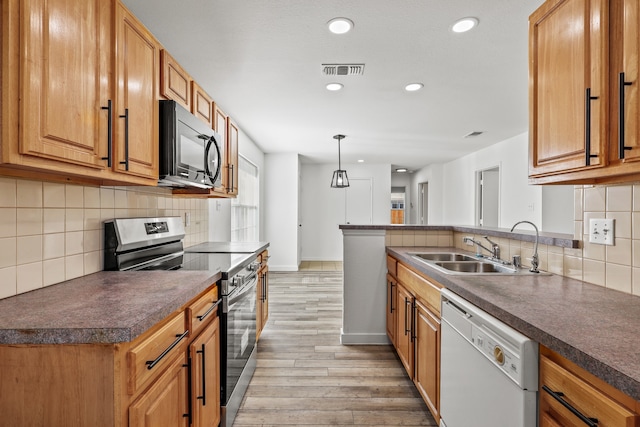 kitchen with stainless steel range, white dishwasher, sink, light hardwood / wood-style flooring, and hanging light fixtures