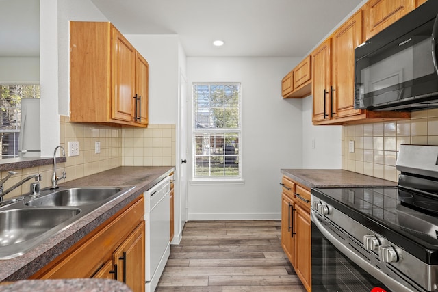 kitchen with stainless steel electric range, light hardwood / wood-style floors, dishwasher, and a wealth of natural light