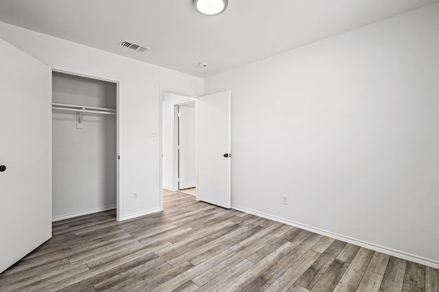 unfurnished bedroom featuring a closet and light wood-type flooring