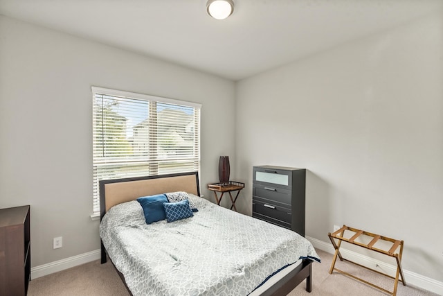 bedroom featuring baseboards and light carpet