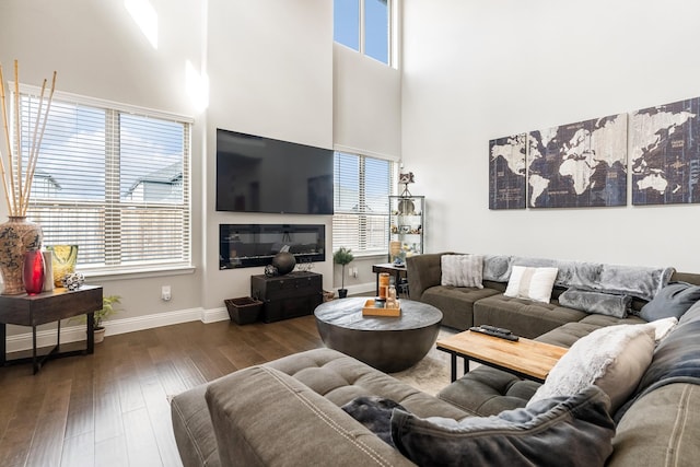 living room with dark wood-type flooring and a high ceiling