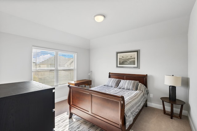 bedroom with baseboards and light colored carpet