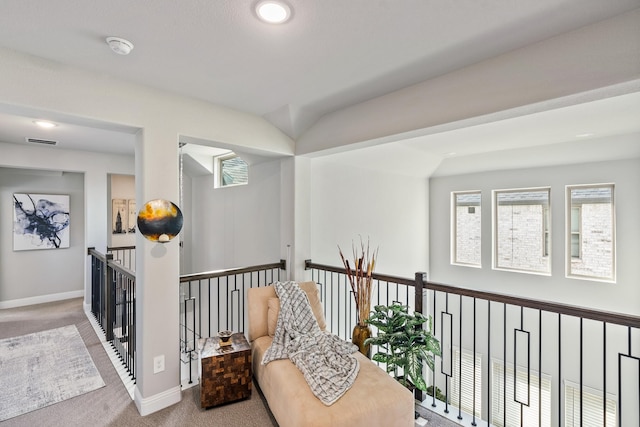 hall featuring an upstairs landing, carpet, visible vents, and baseboards