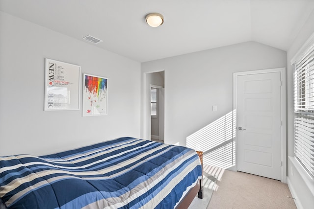 bedroom featuring visible vents, light carpet, and vaulted ceiling