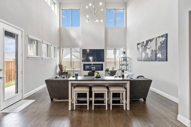 living area featuring dark wood finished floors, plenty of natural light, and an inviting chandelier