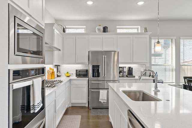 kitchen featuring white cabinets, plenty of natural light, appliances with stainless steel finishes, and a sink