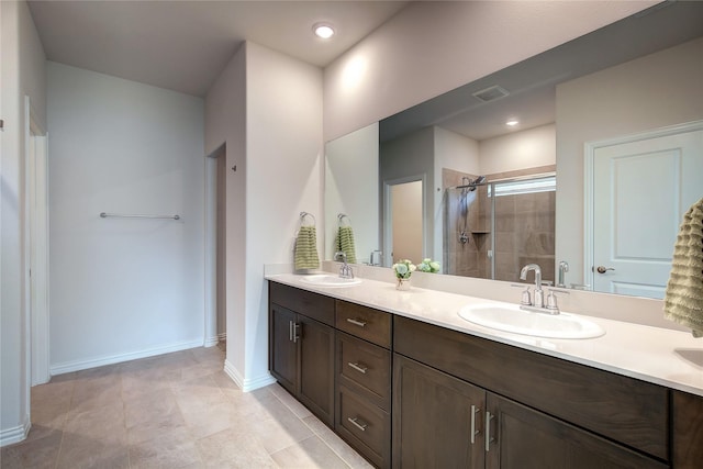 bathroom with tile patterned flooring, vanity, and walk in shower