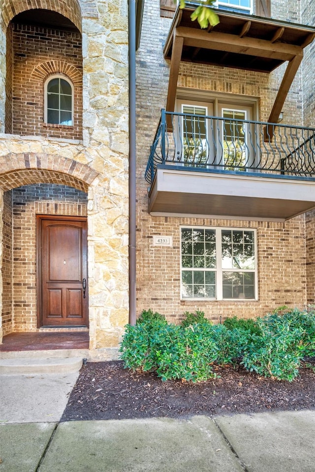 view of exterior entry with a balcony