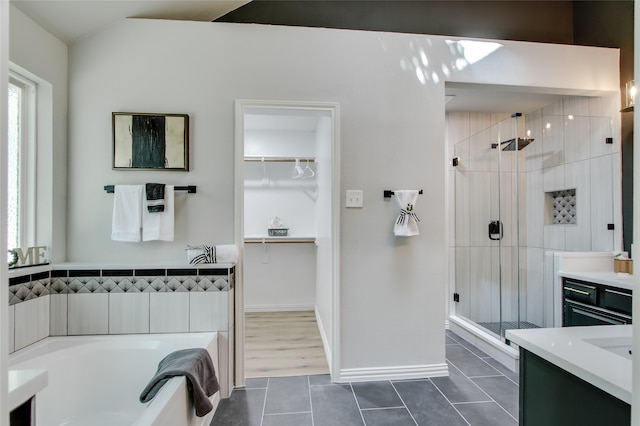 bathroom with tile patterned floors, vanity, and shower with separate bathtub