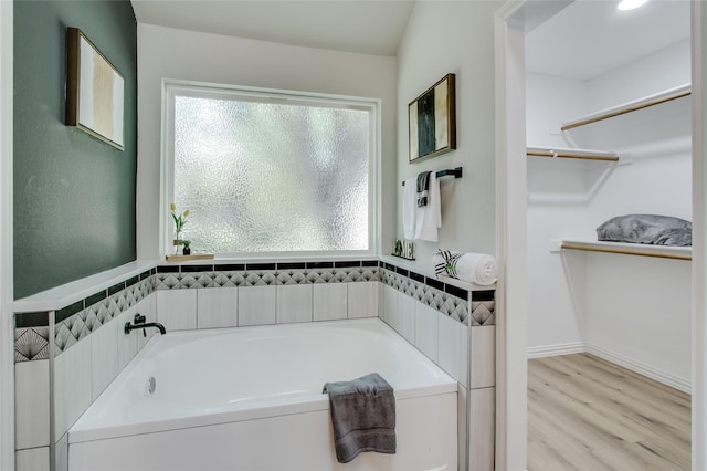 bathroom with hardwood / wood-style floors and a tub