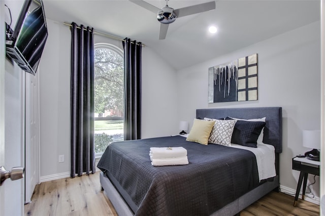 bedroom with hardwood / wood-style flooring, ceiling fan, and lofted ceiling