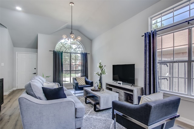 living room with plenty of natural light, a chandelier, and light hardwood / wood-style flooring