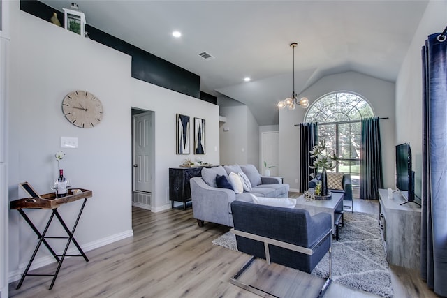 living room with light hardwood / wood-style floors, vaulted ceiling, and a notable chandelier