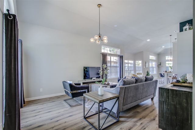 living room featuring hardwood / wood-style floors, vaulted ceiling, and a chandelier