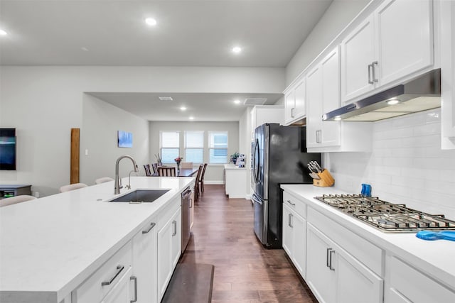 kitchen featuring a center island with sink, white cabinets, sink, dark hardwood / wood-style flooring, and stainless steel appliances