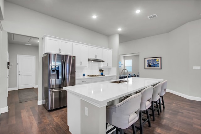 kitchen with sink, dark hardwood / wood-style flooring, an island with sink, white cabinets, and appliances with stainless steel finishes