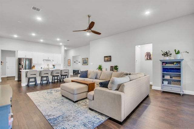 living room featuring dark hardwood / wood-style floors, ceiling fan, and sink