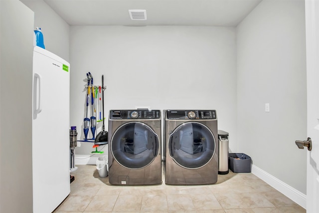 washroom featuring light tile patterned flooring and washer and dryer