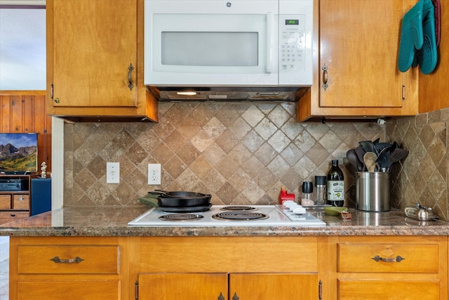 kitchen featuring backsplash and white appliances