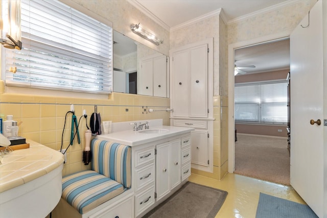 bathroom with vanity, crown molding, ceiling fan, toilet, and tile walls