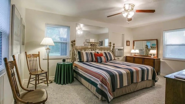 bedroom featuring multiple windows, ceiling fan, and light colored carpet