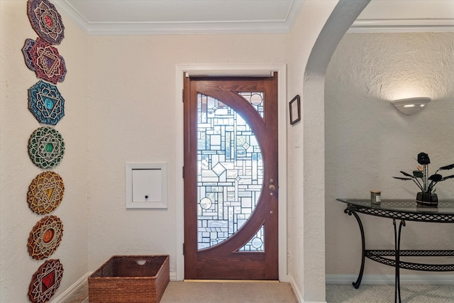 foyer entrance with light colored carpet and ornamental molding